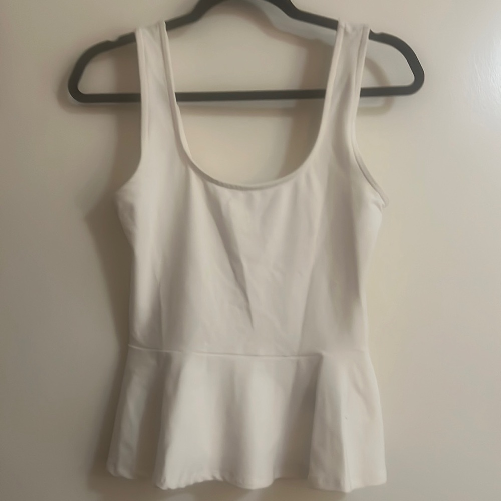 Bebe white tank with ruffle at bottom. Size M.